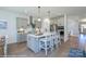 Stylish kitchen boasts gray cabinetry, stainless steel appliances, a center island with seating, and hardwood floors at 2007 Mantle Ridge Dr # 192, Indian Trail, NC 28079