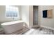 Serene bathroom with soaking tub and tiled shower, featuring wood-look flooring at 209 Sheffield Dr, York, SC 29745