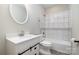 Bright bathroom with a tub and shower combo featuring tiled walls, a modern vanity, and a sleek, round mirror at 209 Sheffield Dr, York, SC 29745