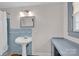 Bathroom featuring a blue-tiled shower, pedestal sink and vanity at 218 N Bost St, Statesville, NC 28677