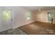 Cozy bedroom with neutral carpet, a large window, and closet organizers, creating a comfortable living space at 218 N Bost St, Statesville, NC 28677