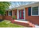 Inviting front entrance featuring bright red double doors and classic brick accents at 218 N Bost St, Statesville, NC 28677