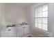 Charming kitchenette with marble-look countertop, mini fridge, sink, and window providing natural light at 218 N Bost St, Statesville, NC 28677