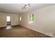 Bright living room with neutral walls, a large window, and carpeted flooring, creating a welcoming atmosphere at 218 N Bost St, Statesville, NC 28677