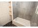 Bathroom featuring new tub with gray tiled walls and modern fixtures at 306 E Burnsville St, Wadesboro, NC 28170