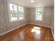 Bright bedroom with natural light, wood paneling, and hardwood floors at 306 E Burnsville St, Wadesboro, NC 28170