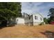 Home's exterior showcasing light siding, a retaining wall, and a well-maintained yard at 306 E Burnsville St, Wadesboro, NC 28170