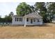 Well-maintained single-story house with a welcoming porch, light siding, and dark shutters in a serene setting at 306 E Burnsville St, Wadesboro, NC 28170