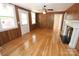Cozy living room featuring hardwood floors, a wood-burning fireplace, wood trim, and great natural light at 306 E Burnsville St, Wadesboro, NC 28170