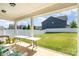 Covered back patio with outdoor seating and a view of the expansive fenced backyard and neighboring homes at 4406 Huntley Glen Dr, Pineville, NC 28134