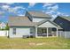 Backyard featuring a covered patio with seating and a well-maintained lawn at 4406 Huntley Glen Dr, Pineville, NC 28134