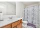 Bathroom with white walls and a blue shower curtain and a vanity sink and toilet at 4406 Huntley Glen Dr, Pineville, NC 28134