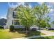 Inviting two-story home featuring a front porch, lush lawn, and mature trees at 4406 Huntley Glen Dr, Pineville, NC 28134