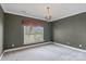 Spacious bedroom with neutral paint, carpet floors, large window, and chandelier at 4465 3Rd Nw St, Hickory, NC 28601