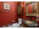 Elegant powder room featuring a unique vessel sink, ornate mirror, and classic red wall color at 4465 3Rd Nw St, Hickory, NC 28601