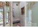 Shower featuring stone tile walls, bench, and a unique piece of art, near a door to the outside at 4465 3Rd Nw St, Hickory, NC 28601