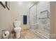 Well-lit bathroom featuring a walk-in shower with glass door and marble tile at 4561 Walden Pond Trwy, Concord, NC 28025