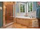 Serene bathroom with bathtub, glass-enclosed shower, and neutral tile surround at 4561 Walden Pond Trwy, Concord, NC 28025