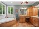 Elegant bathroom with tub, tile surround, and natural light from a large window at 4561 Walden Pond Trwy, Concord, NC 28025