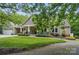 Charming home featuring a spacious front porch, well-manicured lawn, and beautiful landscaping at 4561 Walden Pond Trwy, Concord, NC 28025