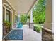 Inviting front porch with blue rocking chairs, stone columns, and tiled flooring at 4561 Walden Pond Trwy, Concord, NC 28025