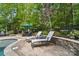 Relaxing patio with lounge chairs, stone retaining wall, and umbrella-covered dining table near the pool at 4561 Walden Pond Trwy, Concord, NC 28025