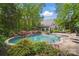 Beautiful in-ground pool and spa surrounded by lush greenery and a spacious patio at 4561 Walden Pond Trwy, Concord, NC 28025