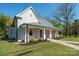 Inviting home featuring a charming front porch, complemented by fresh landscaping and a well-manicured lawn at 600 3Rd St, Spencer, NC 28159