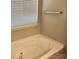 Bathtub with brushed nickel fixture below a window with white blinds in a neutral bathroom at 616 Mountain Quail Dr, Charlotte, NC 28216