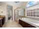 A luxurious main bathroom featuring a glass shower, soaking tub, and natural light from the arched window at 630 Deberry Holw, Rock Hill, SC 29732