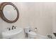 Well-lit powder room with a pedestal sink, toilet, and a decorative mirror at 630 Deberry Holw, Rock Hill, SC 29732