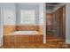 Bathroom with a soaking tub, tiled walls, and a glass-enclosed shower at 648 Revival Row, Fort Mill, SC 29708