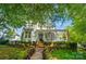Inviting two-story home with a charming front porch, lush landscaping, and mature trees at 648 Revival Row, Fort Mill, SC 29708