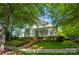 Beautiful two-story home featuring a classic front porch, surrounded by mature trees and greenery at 648 Revival Row, Fort Mill, SC 29708