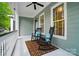 Inviting front porch with rocking chairs, ceiling fan, and decorative outdoor rug and trees at 648 Revival Row, Fort Mill, SC 29708