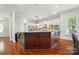 Open kitchen featuring a center island with white cabinetry, modern appliances, and hardwood floors at 648 Revival Row, Fort Mill, SC 29708