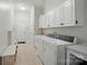 Laundry room with tile floors, washer, dryer, sink and ample white cabinets at 648 Revival Row, Fort Mill, SC 29708