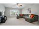 Spacious living room with a large window, ceiling fan, and cozy sectional sofa at 648 Revival Row, Fort Mill, SC 29708