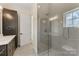 Bathroom featuring a glass-enclosed shower, vanity with dark wood cabinets, and tile flooring at 6511 Rehobeth Rd, Waxhaw, NC 28173