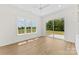 Bright bedroom featuring hardwood floors, a ceiling fan, and large windows and sliding door with backyard views at 6511 Rehobeth Rd, Waxhaw, NC 28173