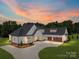 Stunning exterior of a modern farmhouse with a three-car garage and long driveway at 6511 Rehobeth Rd, Waxhaw, NC 28173