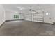 Spacious three-car garage with ample room for vehicles and storage, featuring bright lighting at 6511 Rehobeth Rd, Waxhaw, NC 28173