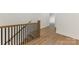 Hallway with hardwood floors and wooden banister with black iron spindles at 6511 Rehobeth Rd, Waxhaw, NC 28173