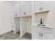 Laundry room area with white cabinets, countertop, sink, and gray tile floors at 6511 Rehobeth Rd, Waxhaw, NC 28173