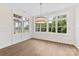 Bright living room featuring large windows, white walls, hardwood floors and modern chandelier at 6511 Rehobeth Rd, Waxhaw, NC 28173