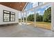 Covered patio with stone accents, a fan, and open views of the lush backyard and trees at 6511 Rehobeth Rd, Waxhaw, NC 28173