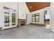 Covered patio with fireplace and access to backyard, featuring stone accents and a ceiling fan at 6511 Rehobeth Rd, Waxhaw, NC 28173