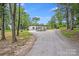 Contemporary home with a gravel driveway nestled among mature trees at 6907 Lancaster Hwy, Waxhaw, NC 28173