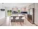 Bright kitchen features an island with seating, stainless steel appliances, modern cabinets, and backyard views at 6907 Lancaster Hwy, Waxhaw, NC 28173