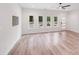Bright living room featuring wood-look floors, a modern ceiling fan and several windows that fill the space with natural light at 6907 Lancaster Hwy, Waxhaw, NC 28173